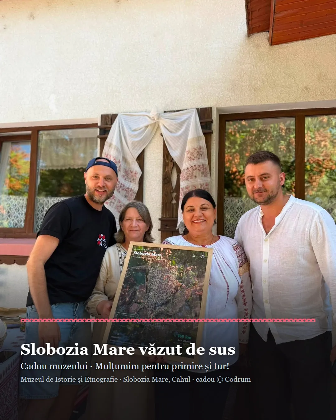 Cadre représentant le village de Slobozia Mare vu du ciel, remis au Musée d'histoire et d'ethnographie, tenu par les hôtes devant le musée